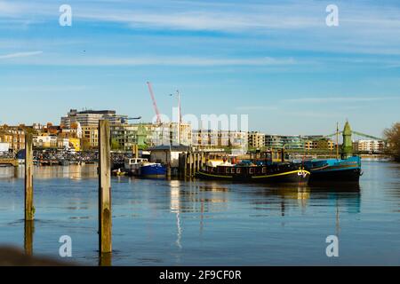 Londra, Regno Unito. 17 Apr 2021. I londinesi navigano e bevono presso l'Upper Mall, Hammersmith, affacciato sul Tamigi. Sole di primavera e un rilassante blocco COVID-19 portano i marinai ai club di vela lungo il Tamigi a Hammersmith e i bevitori alle molte case pubbliche lungo l'Upper Mall. La marea è alta e le case galleggianti risplendono nel sole del pomeriggio. Credit: Peter Hogan/Alamy Live News Foto Stock