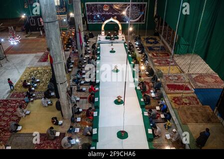 Srinagar, India. 17 Apr 2021. I musulmani del Kashmiri recitano il libro santo islamico Corano durante la recita congregazionale del Santo Corano il 4° giorno del Ramadan in un Imam Badah a Srinagar.il mese più sacro dell'Islam, Ramadan, è un periodo di intensa preghiera, digiuno da alba a tramonto e feste notturne. Khatam al-Quran è una cerimonia normalmente tenuta dai musulmani verso la fine del Ramadan. L'osservanza segna il completamento della lettura dei 30 capitoli (Juzuk) dell'al-Quran. (Foto di Idrees Abbas/SOPA Images/Sipa USA) Credit: Sipa USA/Alamy Live News Foto Stock