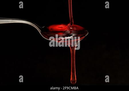 versare lo sciroppo in un cucchiaio Foto Stock