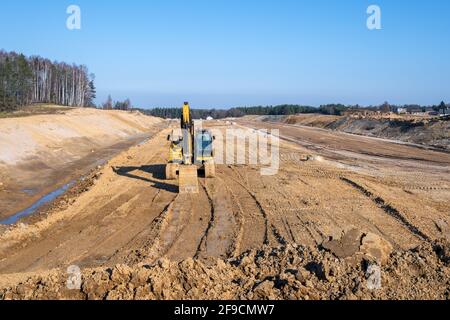 Escavatore su un cantiere autostradale. Lavori di costruzione di strade Foto Stock