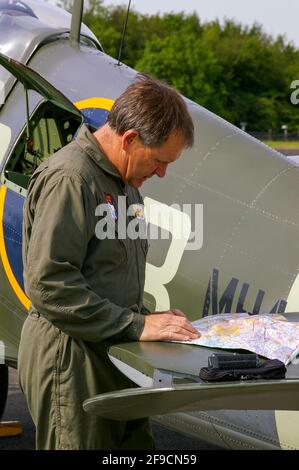 Il pilota Nigel Lamb si prepara al volo in aereo da combattimento della seconda guerra mondiale Supermarine Spitfire IX MH434 a Biggin Hill, Kent, UK. Uso dell'ala come scrivania Foto Stock