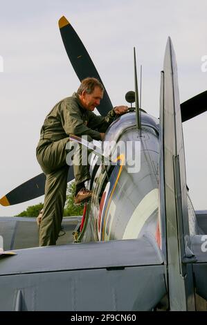 Il pilota Nigel Lamb si prepara al volo in aereo da combattimento della seconda guerra mondiale Supermarine Spitfire IX MH434 a Biggin Hill, Kent, UK. Entrando nel cockpit Foto Stock