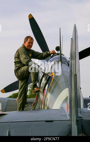 Il pilota Nigel Lamb si prepara al volo in aereo da combattimento della seconda guerra mondiale Supermarine Spitfire IX MH434 a Biggin Hill, Kent, UK. Entrando nel cockpit Foto Stock