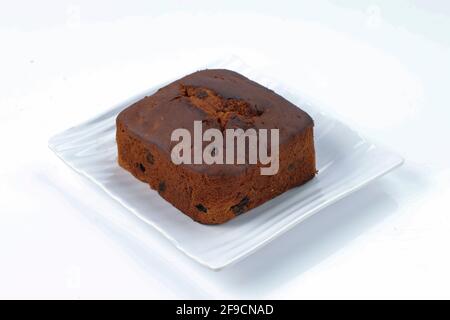 Torta di prugne, torta fatta in casa di cristmus deliziosa utilizzando uvetta, noci di anacardi e frutta secca messi su una tavola bianca con sfondo di colore bianco, i Foto Stock