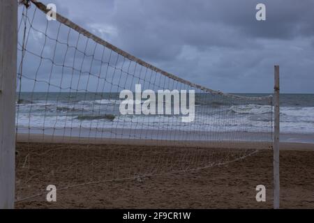 Campo da pallavolo sulla spiaggia senza giocatori in una giornata nuvolosa. Foto Stock