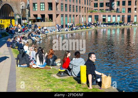 17 aprile 2021 - Londra, Regno Unito, gente che siede lungo il canale di Regents a Camden in un fine settimana soleggiato dopo aver alleggerito il blocco pandemico del coronavirus Foto Stock