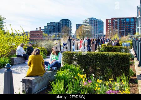 17 aprile 2021 - Londra, Regno Unito, persone che si siedono all'aperto, parlano e socializzano a Coal Drops Yard, Kings Cross in un weekend di sole dopo aver alleggerito il blocco pandemico del coronavirus Foto Stock