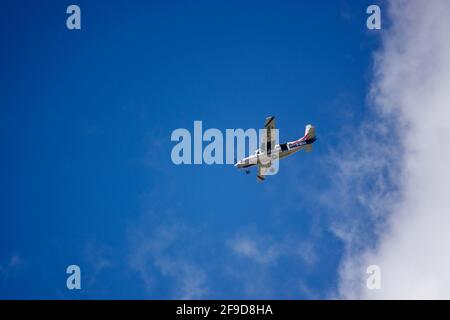 Cessna 208B Grand Caravan torna all'aifueld dopo che il complimento completo di paracadutisti aveva saltato, volando in un cielo nuvoloso blu e bianco chiaro Foto Stock