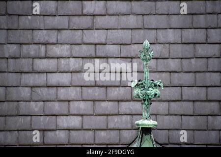 Il tetto in ardesia grigio rettangolare si presenta con una decorazione in rame sul tetto Foto Stock