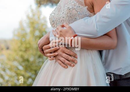 Un closeup ha sparato una sposa e uno sposo abbracciando sul loro giorno di nozze Foto Stock