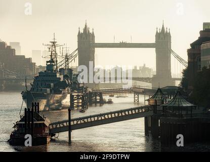 LONDRA, Regno Unito - 01 OTTOBRE 2011: Vista lungo il Tamigi di HMS Belfast e Tower Bridge nella nebbia della mattina presto Foto Stock