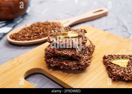 cracker da semi di lino di grano, spezie, e frutta secca tavola di legno, cibo sano. Foto Stock