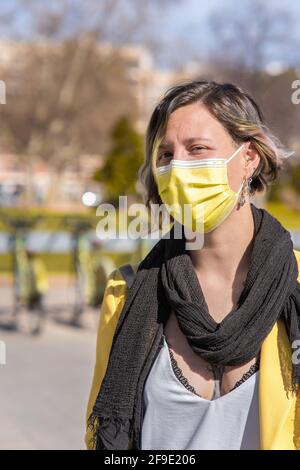 Un colpo verticale di una donna spagnola che indossa un giallo maschera esterna Foto Stock