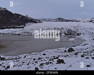 Vista frontale del bordo di Sólheimajökull maestoso, un ghiacciaio di uscita di Mýrdalsjökull, nel sud dell'Islanda circondato da aspre montagne. Foto Stock