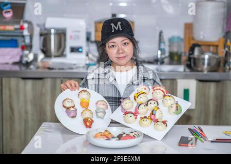 (210418) -- CHONGQING, 18 aprile 2021 (Xinhua) -- Ouyang Qinyun mostra i panini al vapore nel suo studio nel distretto di Yubei del comune di Chongqing della Cina sudoccidentale, 15 aprile 2021. Un capo di abbigliamento-designer-Turned-Cook a Chongqing ha creato una sorprendente chimica tra arte e cottura al vapore. Ouyang Qinyun, 40 anni, è un cuoco cinese dei social media famoso che si specializza nel mun al vapore, o mantou in cinese. Di solito fatto con farina, lievito e acqua di tutti gli usi, il mantou è una base fondamentale in Cina, soprattutto nel nord. "Ho imparato che i mazzi a vapore potevano essere realizzati in forme diverse. Davvero Foto Stock