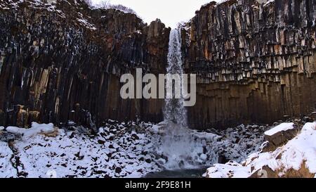 Bella vista della famosa cascata Svartifoss circondato da basalto colonnare vulcanico a forma esagonale nel parco nazionale di Skaftafell, Islanda meridionale. Foto Stock