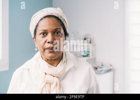Paziente africano americano maturo donna in clinica in attesa di appuntamento durante l'appuntamento Foto Stock