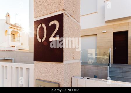 Numeri su posta contro esterni della casa contemporanea con porta d'ingresso e scalinata in città il giorno di sole Foto Stock