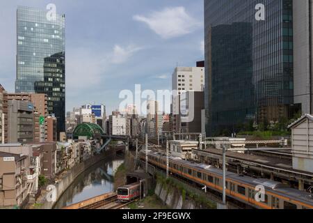 Un treno Tokyo Metro 02 sulla linea Marunouchi passa sotto un treno della serie E233 sulla linea Chuo alla stazione di Ochanomizu, Tokyo, Giappone. Foto Stock