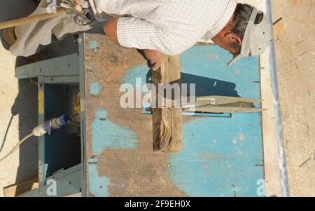 il falegname lavora sulla lavorazione del legno della macchina utensile. Falegname che lavora su macchine per la lavorazione del legno in cantiere. Foto Stock