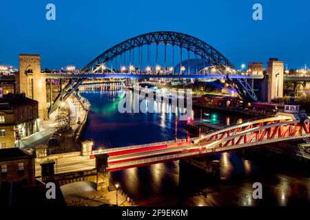 Newcastle upon Tyne UK: 30 marzo 2021: Newcastle Gateshead Quayside di notte, con il ponte di Tyne e lo skyline della città, lunga esposizione durante l'ora blu Foto Stock