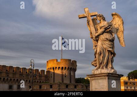 Angelo con la Croce e Castel Sant Angelo sullo sfondo al tramonto a Roma Foto Stock