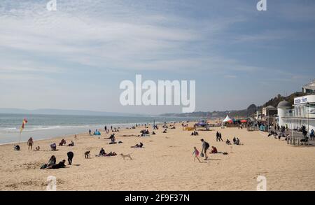 La gente gode del caldo tempo sulla spiaggia a Bournemouth in Dorset. Data immagine: Domenica 18 aprile 2021. Foto Stock