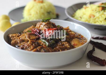 Riso al limone servito con curry di pollo in stile Kerala. Scatto su sfondo bianco. Foto Stock