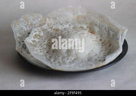 Crepes di riso lacerato o frittelle di riso fermentate fatte con pastella di riso fermentata e latte di cocco. Un piatto preferito per la colazione del Kerala chiamato Appam Foto Stock