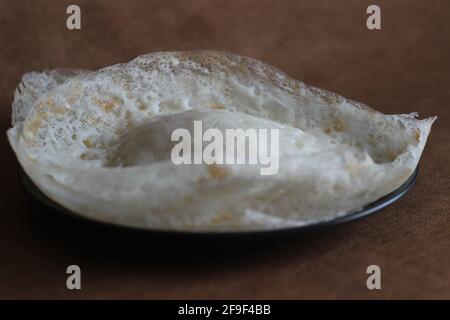 Crepes di riso lacerato o frittelle di riso fermentate fatte con pastella di riso fermentata e latte di cocco. Un piatto preferito per la colazione del Kerala chiamato Appam Foto Stock