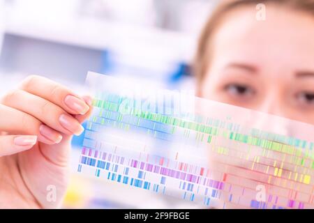 La giovane donna esamina un quadro di spettroscopia in una fisica quantistica laboratorio Foto Stock