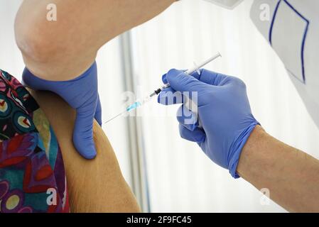 Vaccinazione contro Covid-19, una persona riceve il vaccino del coronavirus. Fuoco selettivo sull'ago Foto Stock
