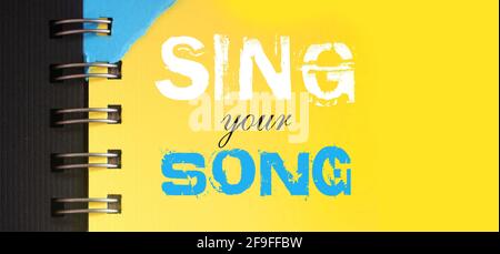 Canta le parole della tua canzone sulla pagina blu cielo di copyybok in bianco e rosa. Concetto di musica. Foto Stock