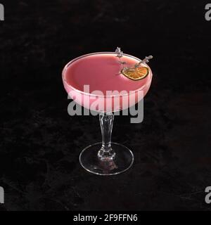 Cocktail rosa con vodka, latte di mandorle, grenadina e panna. Cocktail drink ghiacciato con limone ed erbe. Spazio per il testo. Foto per il menu. Foto Stock