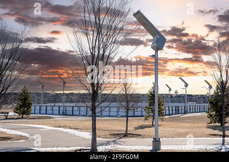 Luci di strada alimentate a energia solare in un parco ricreativo all'aperto che si ricarica all'alba di Airdrie Alberta Canada. Foto Stock