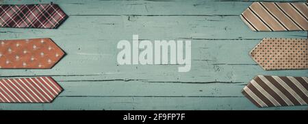 Doppio bordo di cravatte colorate su uno sfondo di legno verde chiaro con spazio per la copia. Foto Stock