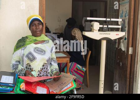 Dodoma, Tanzania. 10-10-2018. Una donna musulmana nera che lavora in ospedale sta organizzando il suo lavoro di carta mentre attende la prossima pazienza di ricevere Foto Stock