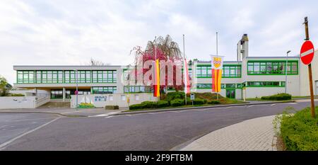 Bornheim, Renania Settentrionale-Vestfalia, Germania - 18 aprile 2021: Bandiere a metà albero in una scuola elementare in lutto per coloro che sono morti di COVID-19 Foto Stock