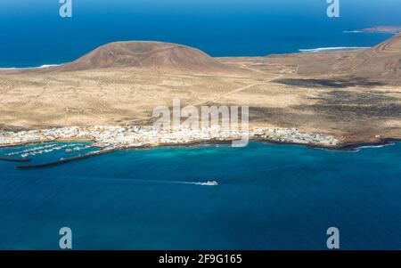 Haría, Lanzarote, Isole Canarie, Spagna. Vista su la Graciosa dal Mirador del Río, traghetto che lascia il porto di Caleta de Sebo. Foto Stock