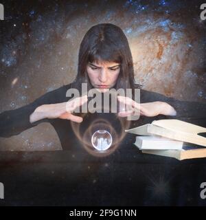 La ragazza tiene le mani su una palla brillante e guarda al futuro accanto a libri magici sullo sfondo di galaxie. Il concetto di abili paranormale Foto Stock