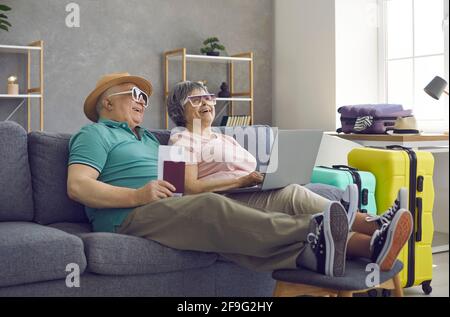 Felice coppia senior che si prepara per la vacanza estiva e la prenotazione camera d'albergo online Foto Stock