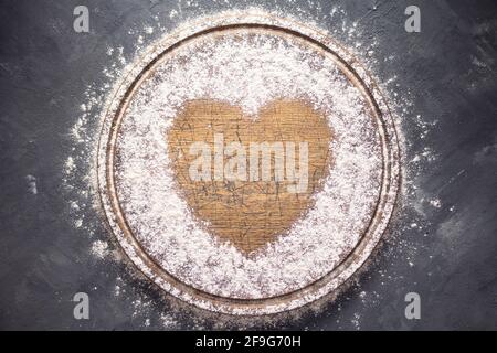 Farina di grano a pizza di legno o tagliere di pane per la cottura fatta in casa sul tavolo. Concetto di ricetta del cibo a trama di fondo di pietra con spazio di copia. Piatto Foto Stock