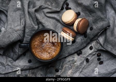 Macaron o macaroon dolci biscotti dessert e una tazza di caffè su un tavolo in legno vista piano Foto Stock