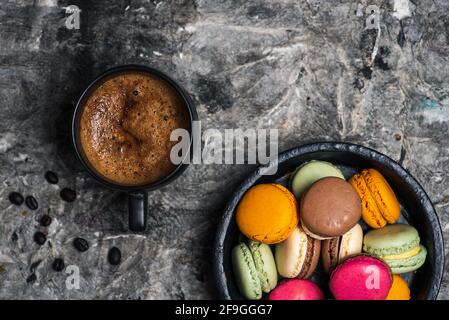 Macaron o macaroon dolci biscotti dessert e una tazza di caffè su un tavolo in legno vista piano Foto Stock