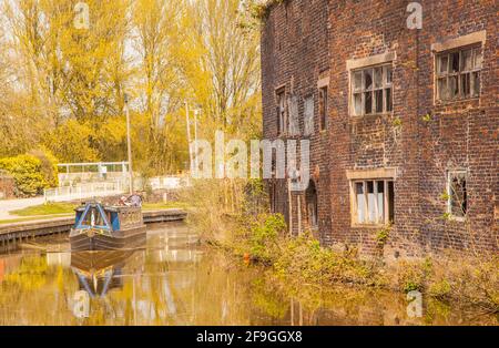 Canale narrowboat sul canale Trent e Mersey passando il Vecchio derelict Kensigton & Price lavori di ceramica e magazzino in Longport Stoke on Trent Foto Stock