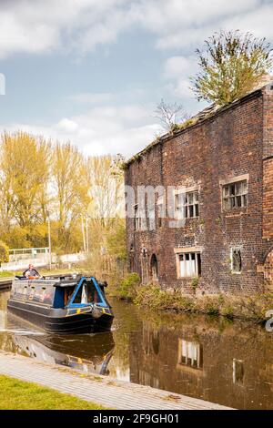 Canale narrowboat sul canale Trent e Mersey passando il Vecchio derelict Kensigton & Price lavori di ceramica e magazzino in Longport Stoke on Trent Foto Stock