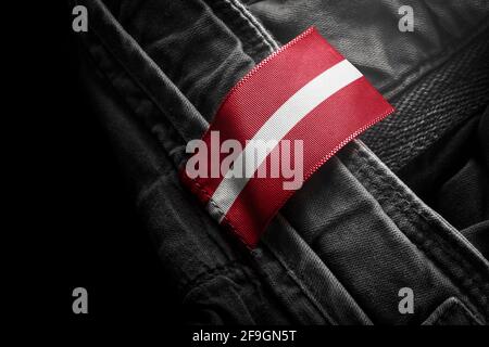 Etichetta su abiti scuri sotto forma di bandiera Della Lettonia Foto Stock