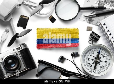 Bandiera della Colombia e accessori da viaggio su sfondo bianco. Foto Stock