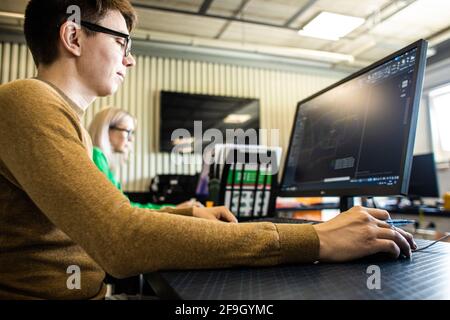 Progettista che lavora su computer desktop in fabbrica Foto Stock