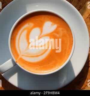 Tè al latte caldo o tè al latte tailandese in tazza il tavolo Foto Stock